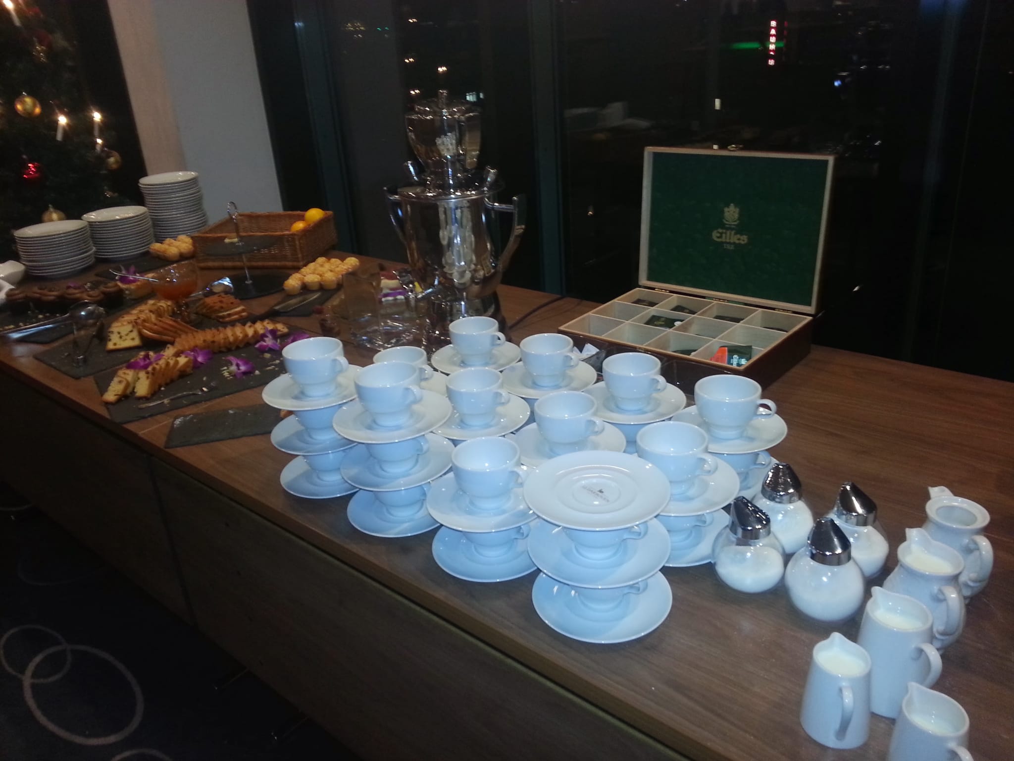 Kaffeestation mit Tassen, Milchkännchen und Gebäck