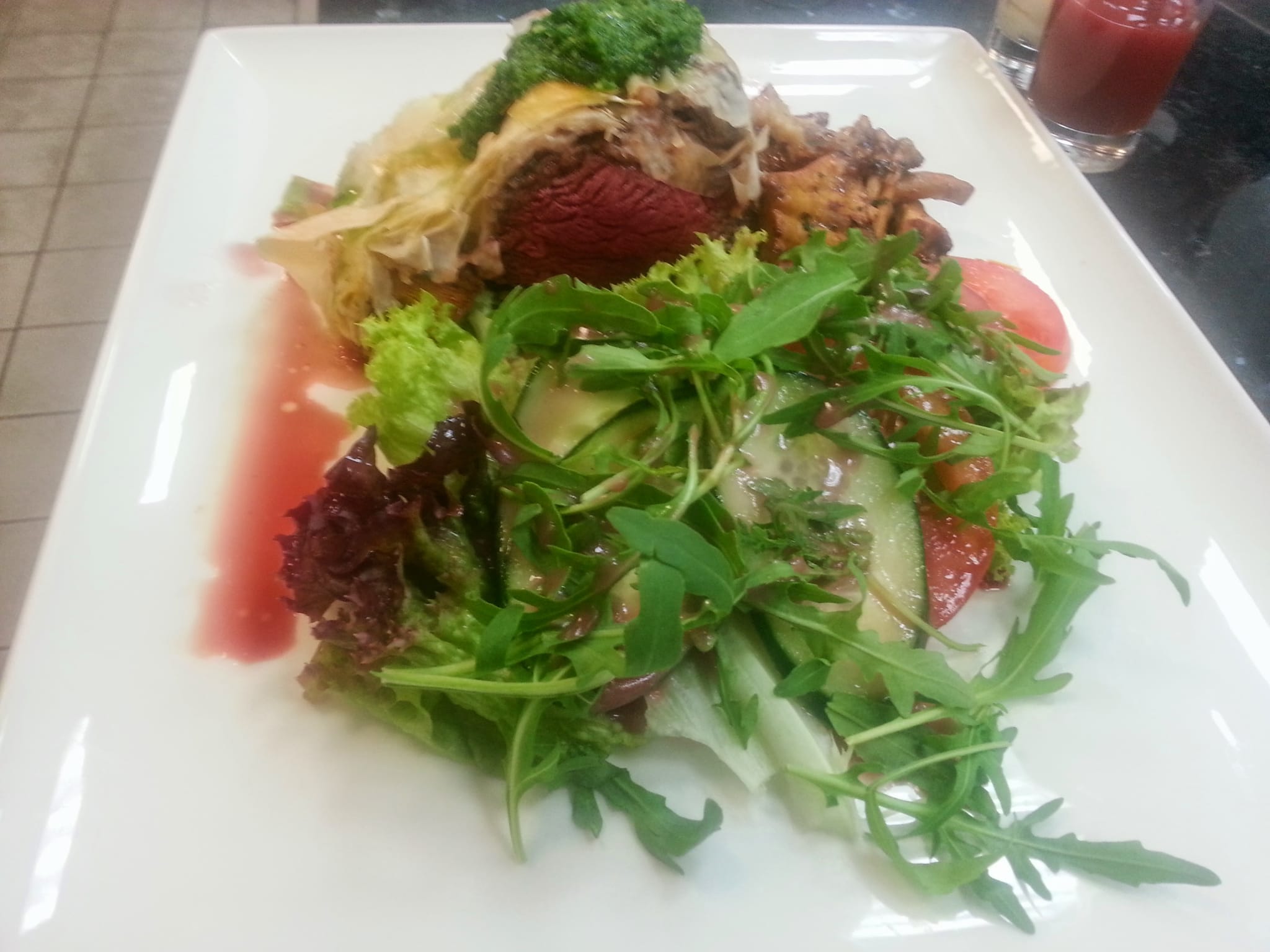 Angerichteter Teller mit rosa Braten und Rucolasalat