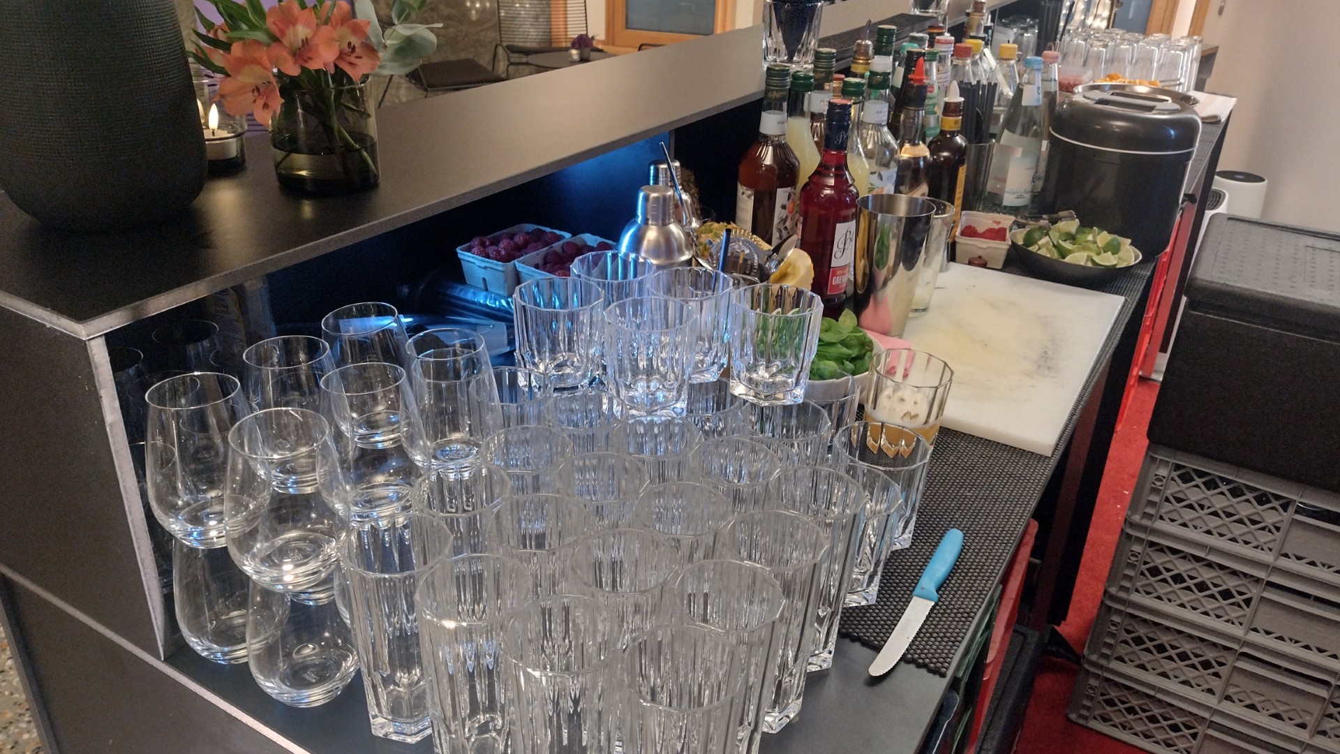 Aufgebaute mobile Bar mit Gläsern, Spirituosen und frischen Zutaten