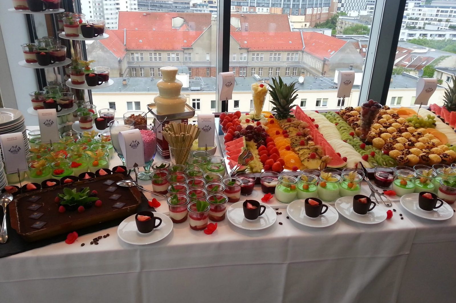 Dessertbuffet mit Schokoladenbrunnen und Obst vor den Dächern Berlins